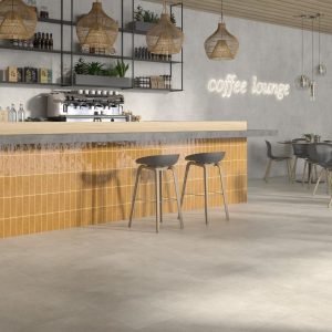 Vita - Café en horeca met gele kleurtegel en lichte betonlook op barfront en vloer, Pamesa