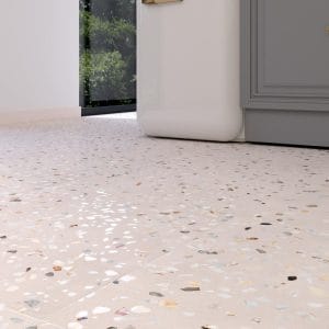 Doria - Detail van een lichte terrazzovloer met grove roze, grijze en beige schilfers, Pamesa