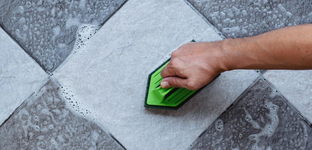 Voegen schoonmaken in een badkamer met een zachte borstel en een voegenreiniger
